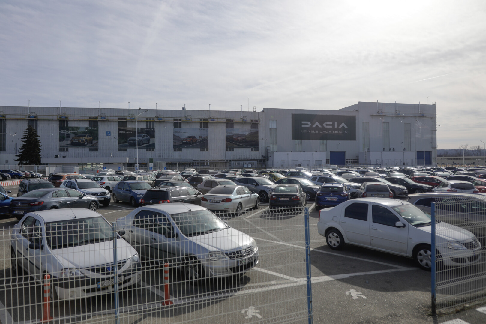 Numeroase autoturisme parcate în curtea unei platforme industriale auto